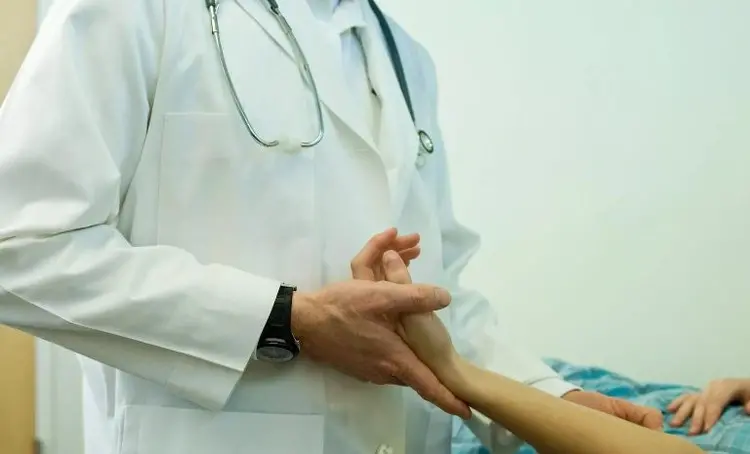 доктор держит пациента за руку